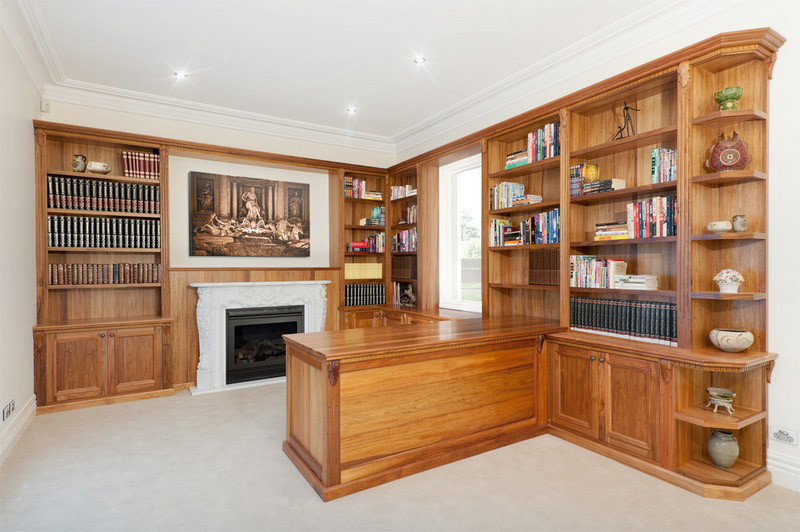 Study room - large traditional built-in desk carpeted study room idea with a standard fireplace and a plaster fireplace