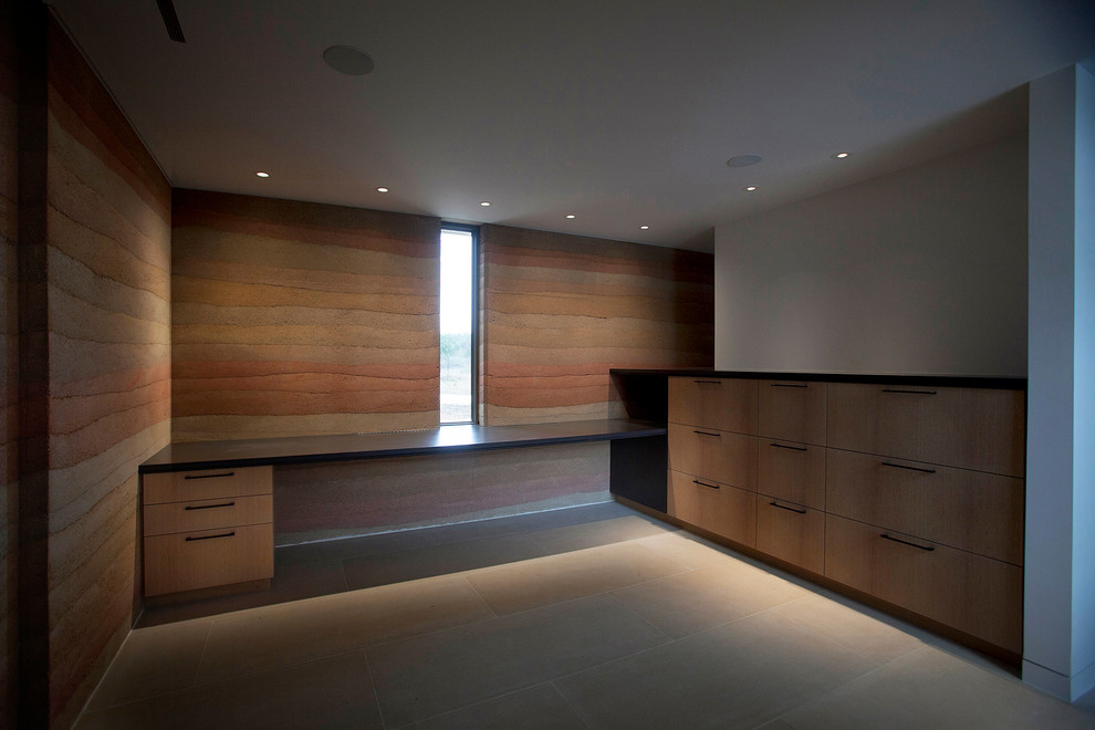 Modelo de despacho minimalista grande sin chimenea con paredes beige, suelo de baldosas de cerámica, escritorio empotrado y suelo gris