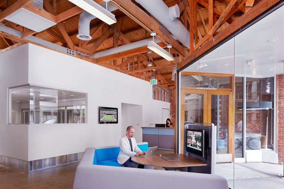 Geräumiges Modernes Arbeitszimmer mit Studio, weißer Wandfarbe, Betonboden und freistehendem Schreibtisch in Los Angeles