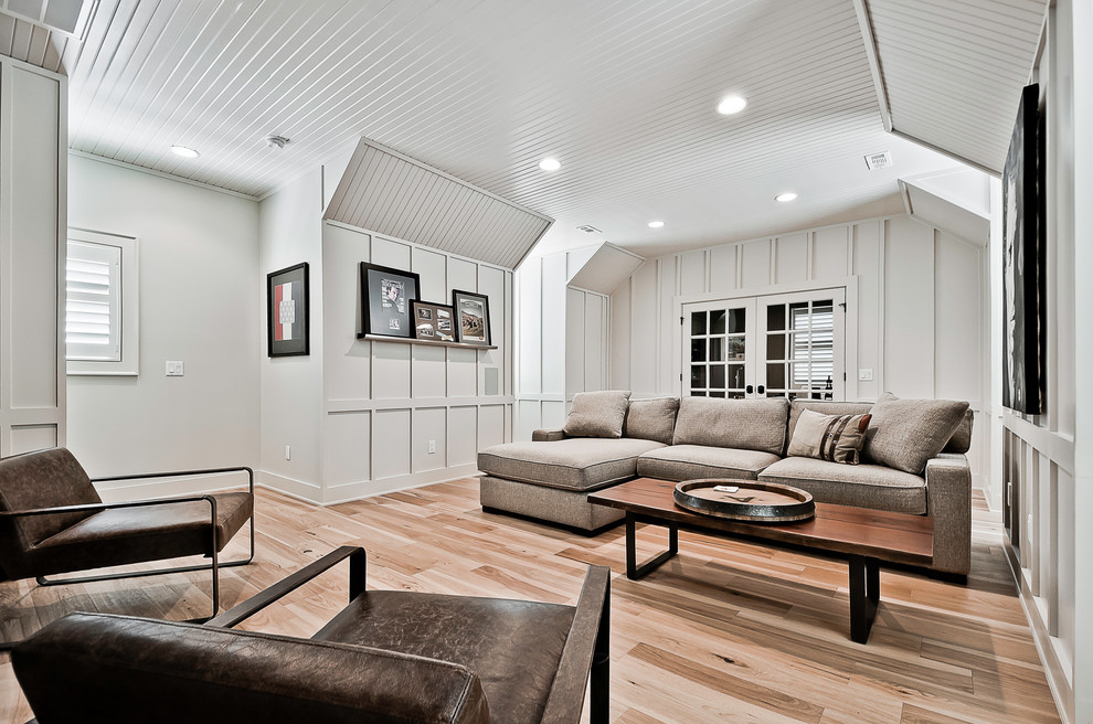 Bild på ett stort amerikanskt hemmastudio, med ljust trägolv och brunt golv