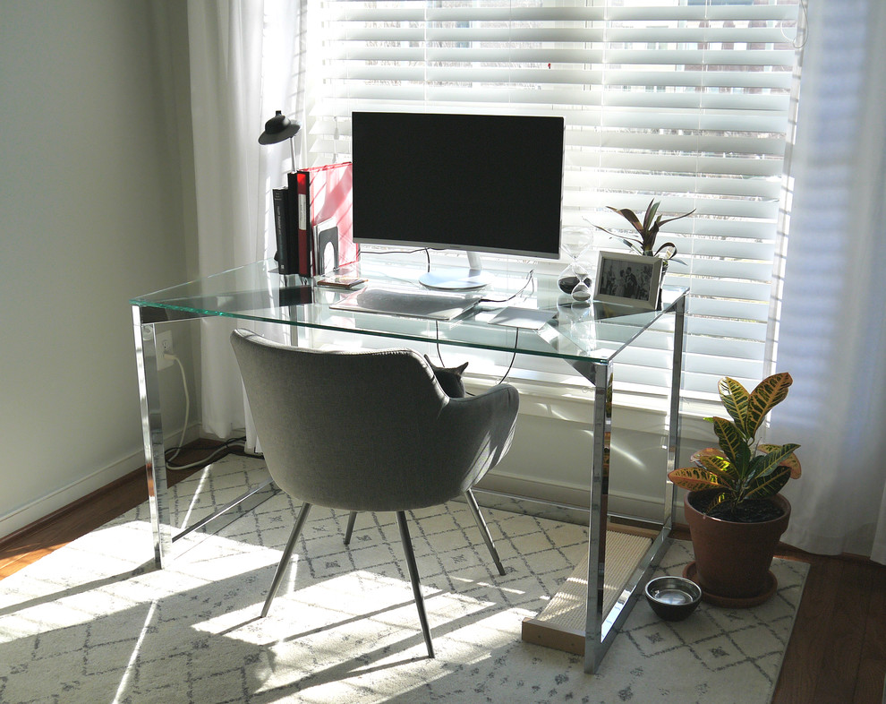 Foto di un piccolo studio minimalista con pareti grigie, scrivania autoportante, pavimento grigio e pavimento in legno massello medio