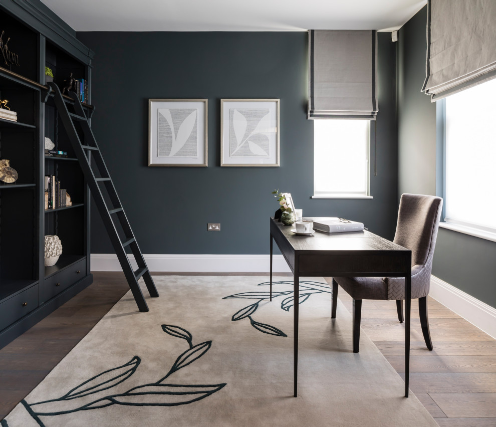 Großes Modernes Arbeitszimmer mit grauer Wandfarbe, braunem Holzboden, freistehendem Schreibtisch und braunem Boden in London