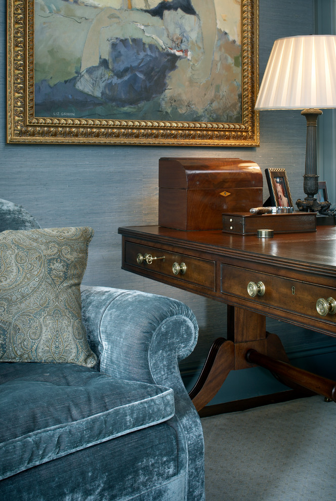 Immagine di un ufficio classico con pareti blu, moquette e scrivania autoportante