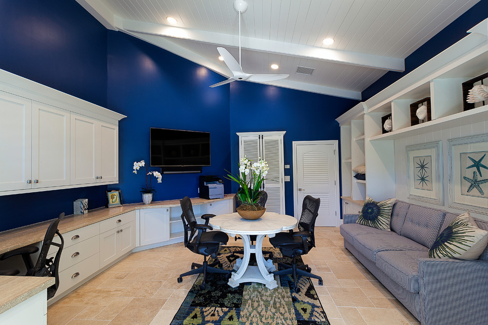 Immagine di un ufficio tropicale di medie dimensioni con pareti blu, pavimento in travertino, scrivania incassata e pavimento beige