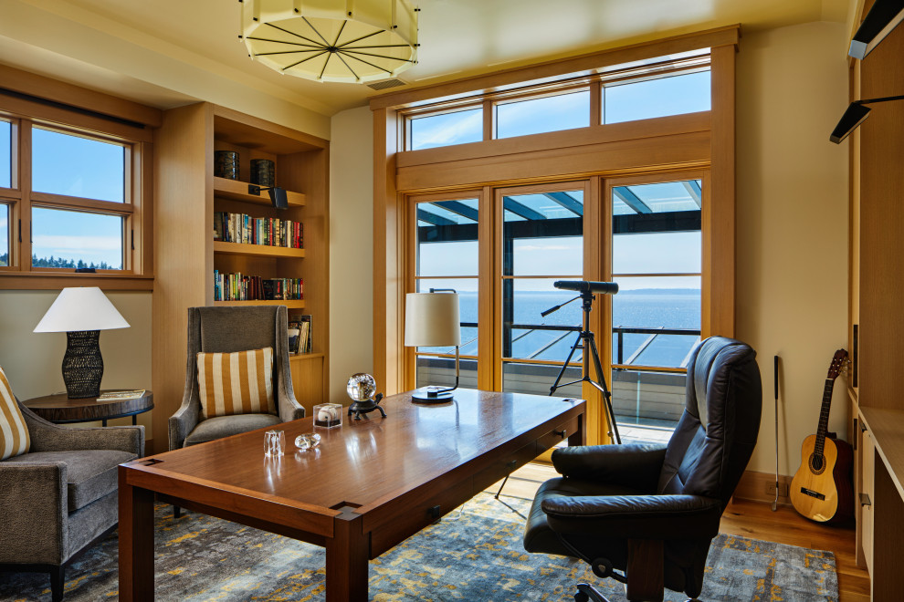 シアトルにあるトランジショナルスタイルのおしゃれなホームオフィス・書斎 (ライブラリー、自立型机、ベージュの壁、無垢フローリング、茶色い床) の写真