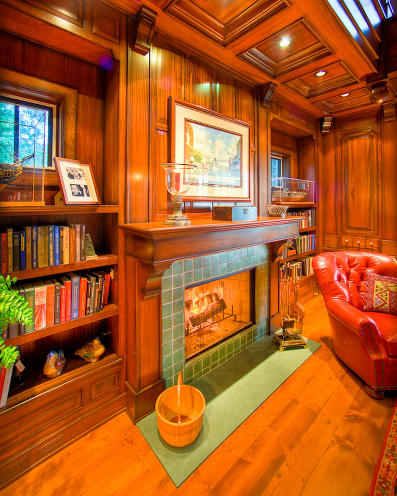 Exempel på ett mycket stort klassiskt hemmabibliotek, med bruna väggar, mellanmörkt trägolv, en standard öppen spis och en spiselkrans i trä