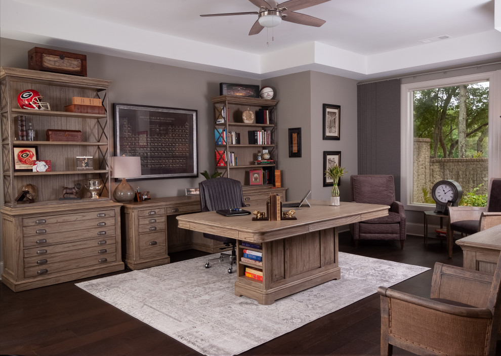 Ejemplo de despacho clásico renovado grande sin chimenea con paredes grises, suelo de madera oscura, escritorio independiente y suelo marrón