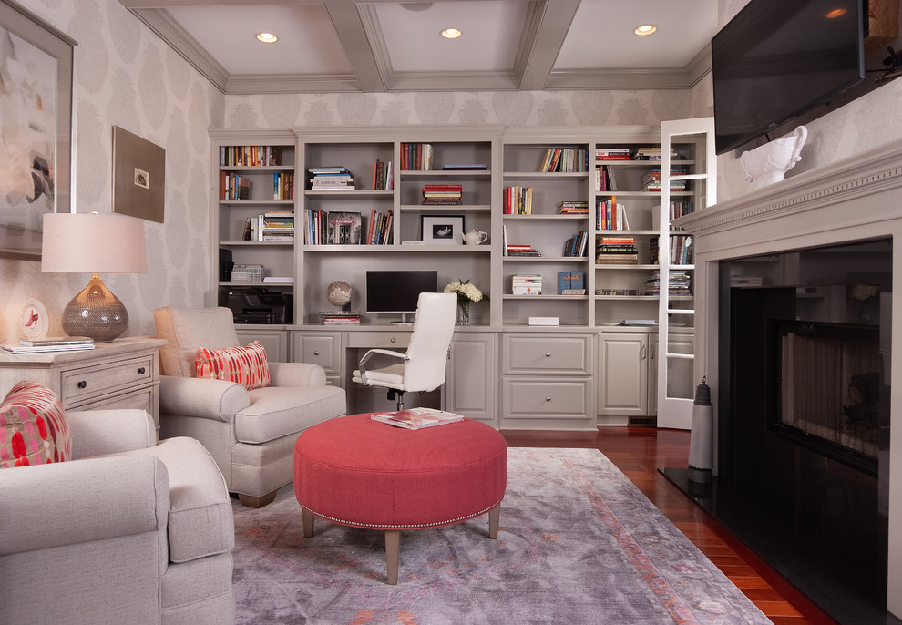 Home office library - mid-sized traditional built-in desk medium tone wood floor home office library idea in Atlanta with a two-sided fireplace and gray walls