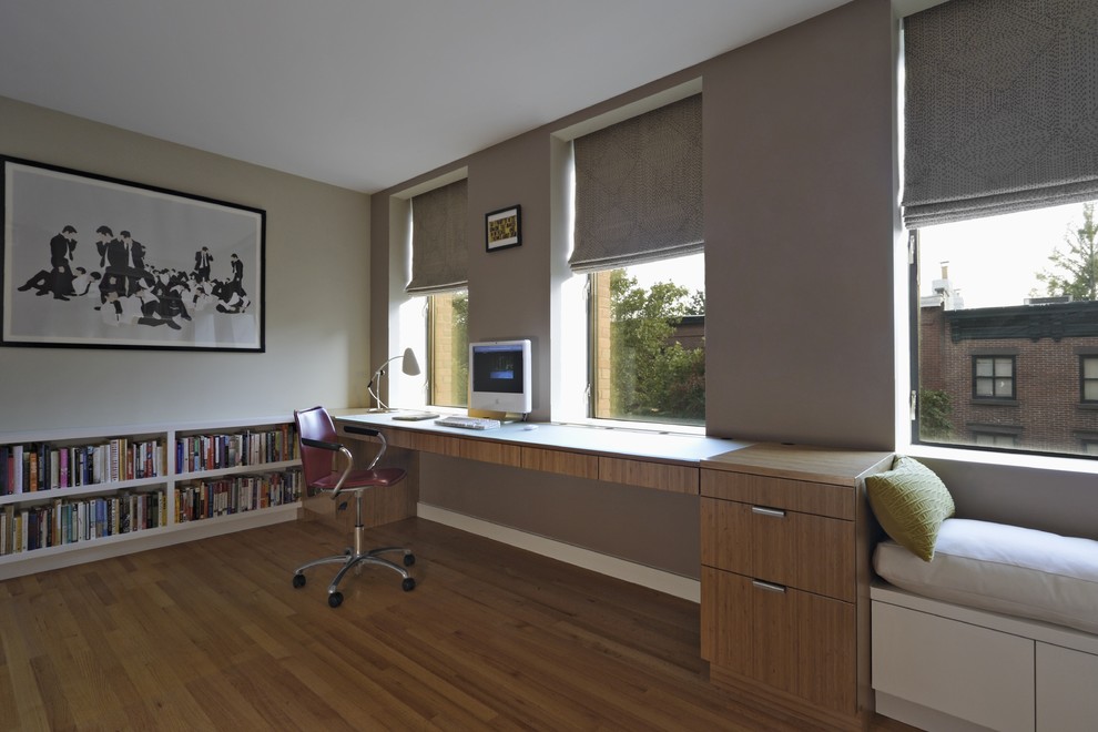 Пример оригинального дизайна: большое рабочее место в стиле модернизм с бежевыми стенами, паркетным полом среднего тона и отдельно стоящим рабочим столом