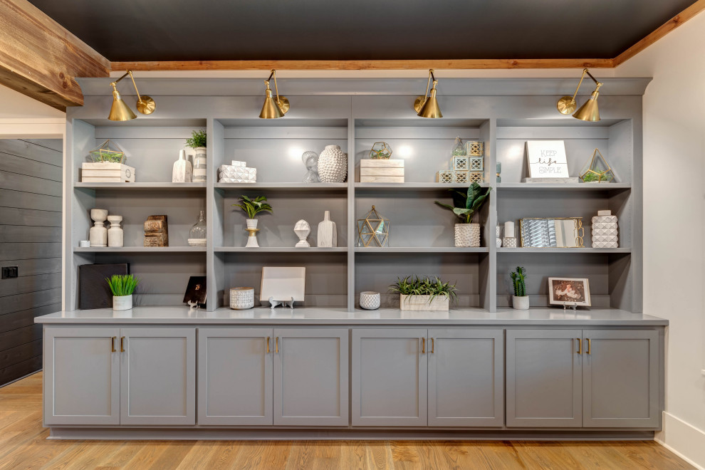 Ejemplo de despacho minimalista grande con biblioteca, paredes grises, suelo de madera en tonos medios, suelo marrón, vigas vistas y machihembrado
