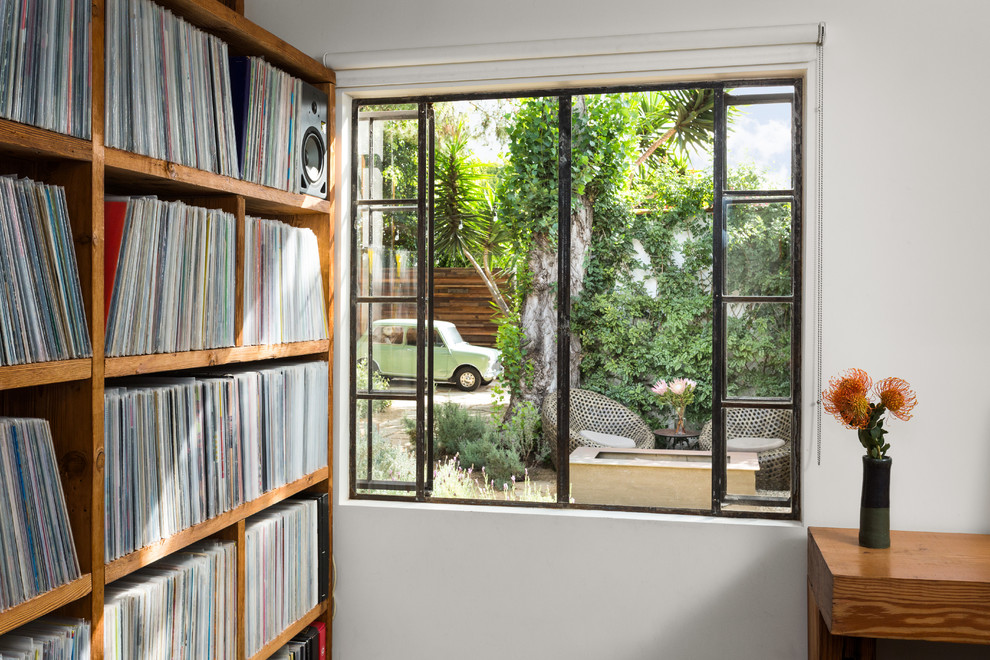 Kleines Modernes Lesezimmer ohne Kamin mit weißer Wandfarbe, braunem Holzboden, freistehendem Schreibtisch und braunem Boden in Los Angeles