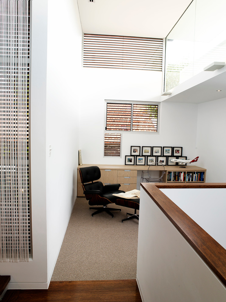 Пример оригинального дизайна: рабочее место среднего размера в современном стиле с белыми стенами, ковровым покрытием и встроенным рабочим столом