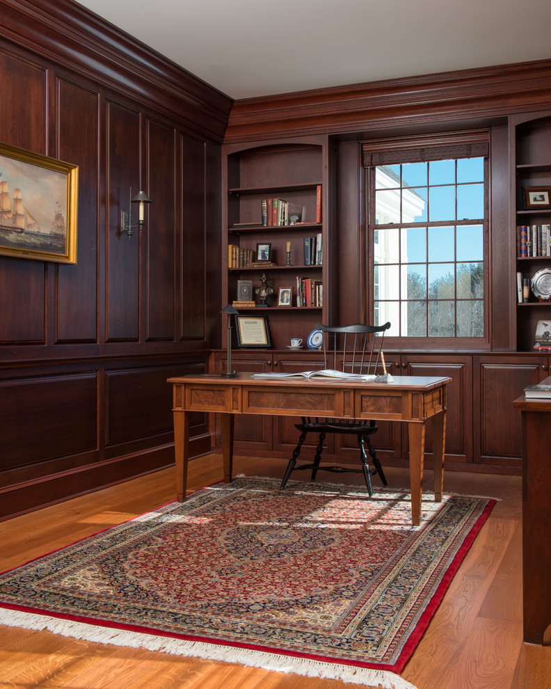 Imagen de despacho tradicional con suelo de madera en tonos medios y escritorio independiente