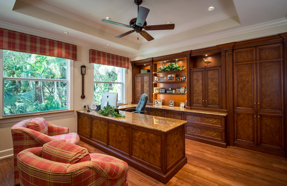 Imagen de despacho clásico con paredes blancas, suelo de madera en tonos medios y escritorio empotrado