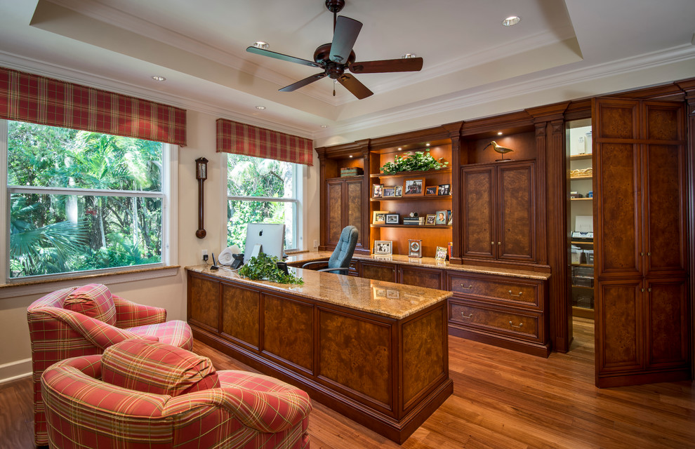Diseño de despacho tradicional con paredes beige, suelo de madera en tonos medios y escritorio empotrado