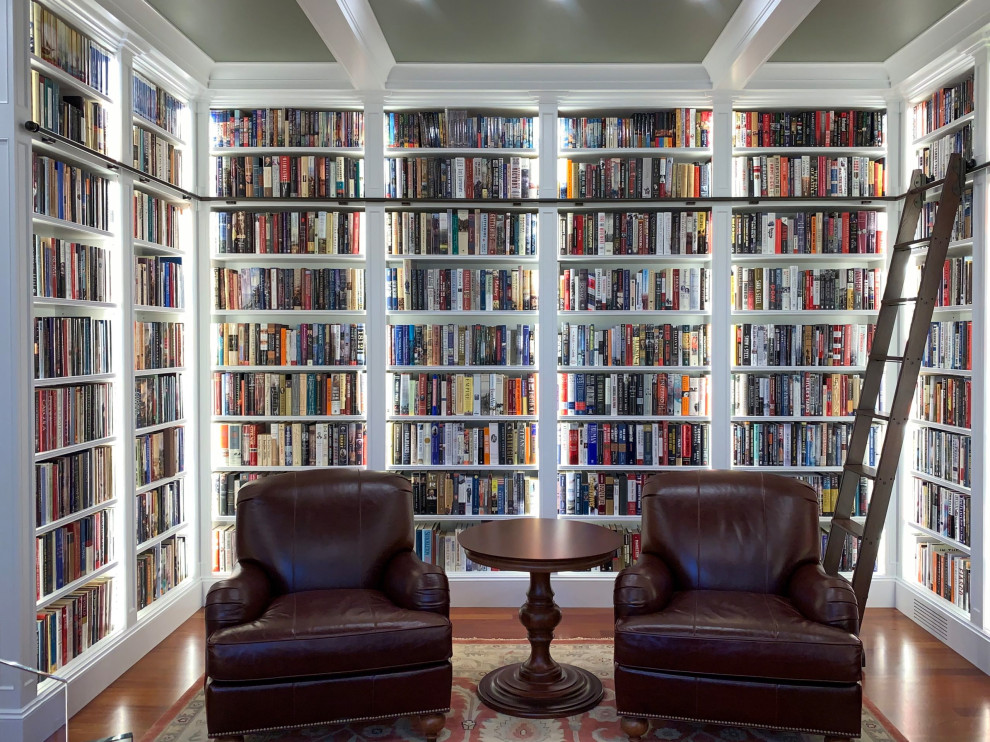 Foto de despacho clásico de tamaño medio con biblioteca, paredes verdes, suelo de madera en tonos medios, suelo naranja, casetón y panelado