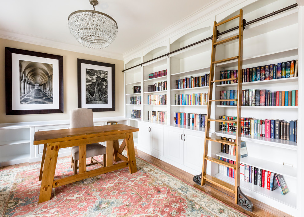 Ejemplo de despacho clásico renovado con paredes beige, suelo de madera en tonos medios, escritorio independiente y suelo marrón
