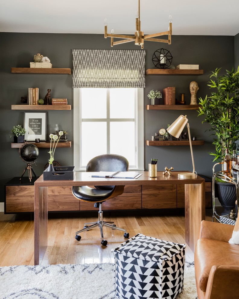 Example of a trendy freestanding desk medium tone wood floor and brown floor study room design in Boston with gray walls