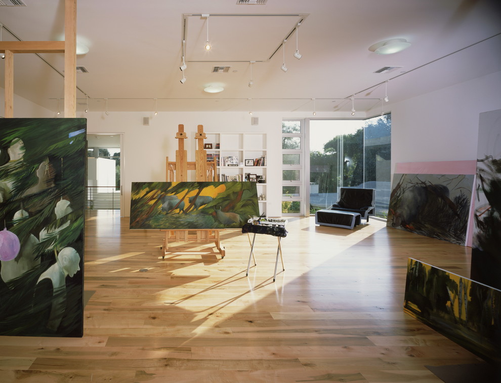 Esempio di un atelier minimalista con pareti bianche, pavimento in legno massello medio e pavimento beige