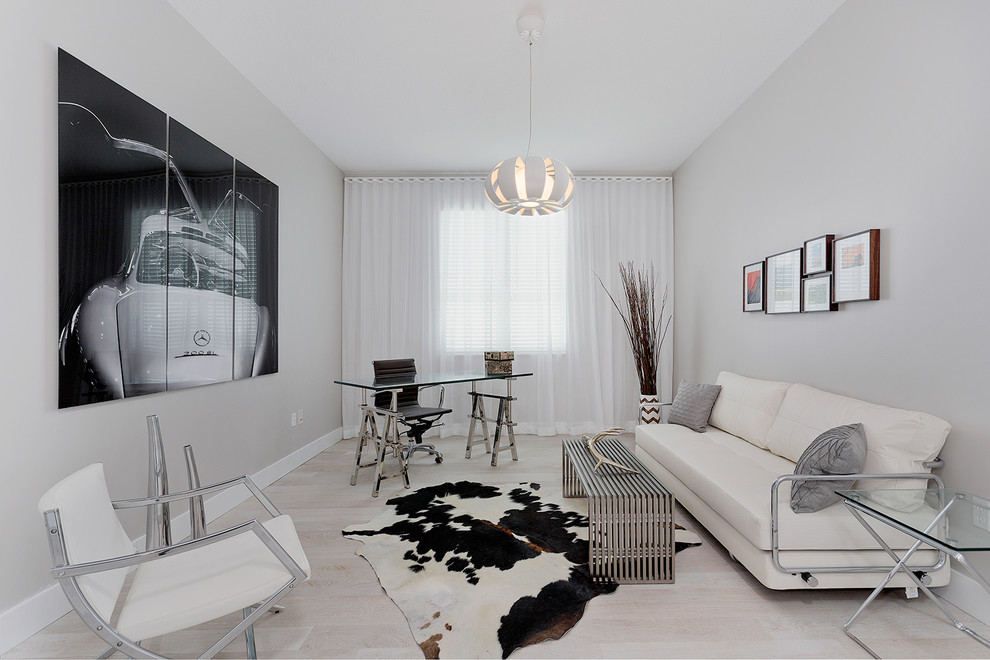Medium sized contemporary study in Miami with grey walls, light hardwood flooring, no fireplace and a freestanding desk.