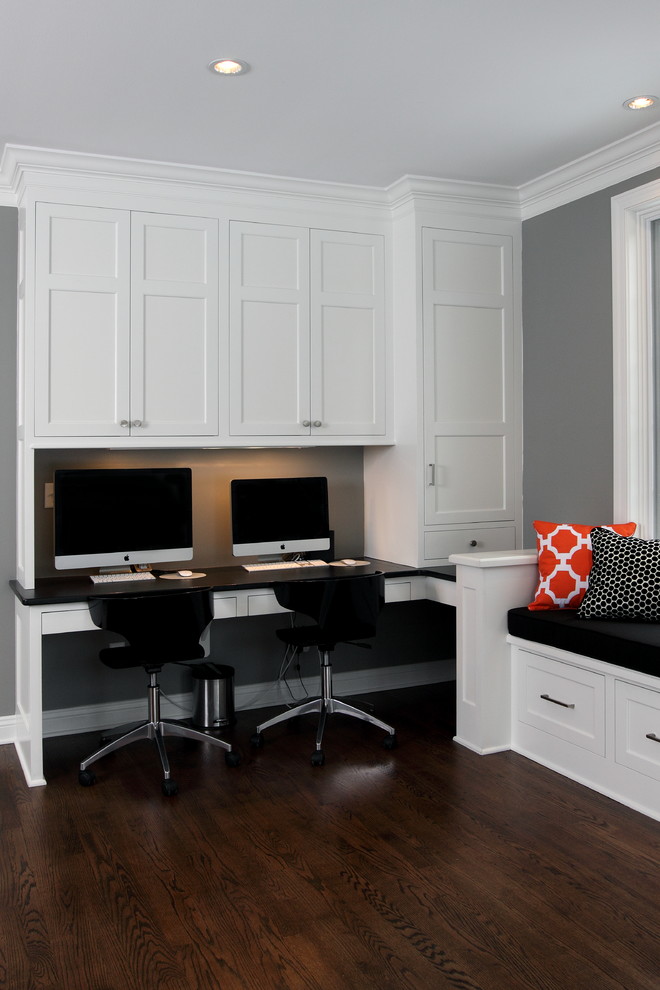 Modelo de despacho clásico de tamaño medio sin chimenea con paredes grises, suelo de madera oscura y escritorio empotrado