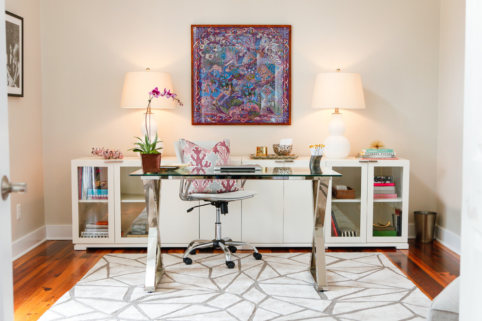 Inredning av ett klassiskt arbetsrum, med beige väggar, mörkt trägolv och ett fristående skrivbord