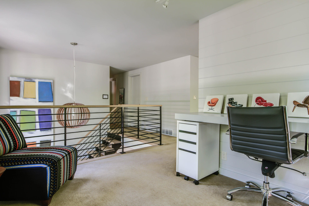 Mittelgroßes Retro Arbeitszimmer ohne Kamin mit Arbeitsplatz, weißer Wandfarbe, Teppichboden und Einbau-Schreibtisch in Grand Rapids