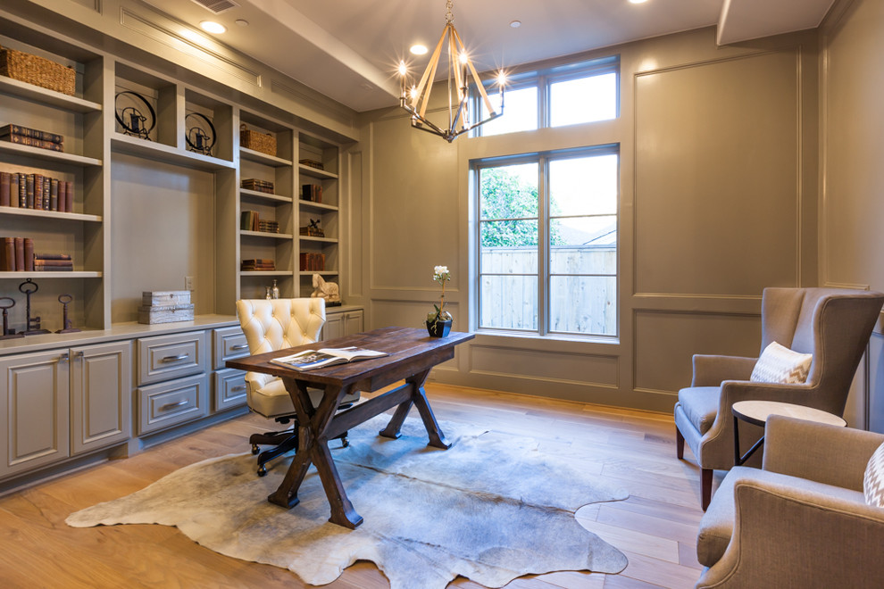 Mittelgroßes Klassisches Arbeitszimmer ohne Kamin mit Arbeitsplatz, grauer Wandfarbe, hellem Holzboden und freistehendem Schreibtisch in Houston