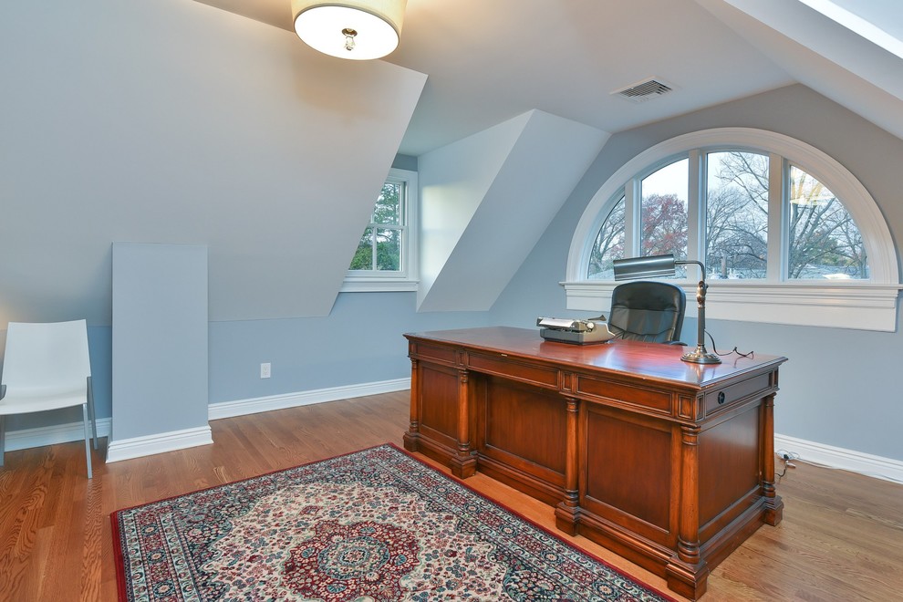 Идея дизайна: кабинет среднего размера в викторианском стиле с синими стенами, паркетным полом среднего тона и отдельно стоящим рабочим столом