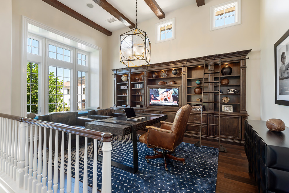 Foto de despacho clásico renovado grande con suelo de madera oscura, escritorio independiente, suelo marrón y paredes beige