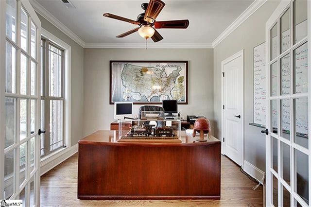 Imagen de despacho de estilo americano de tamaño medio sin chimenea con paredes grises, suelo de madera en tonos medios y escritorio independiente