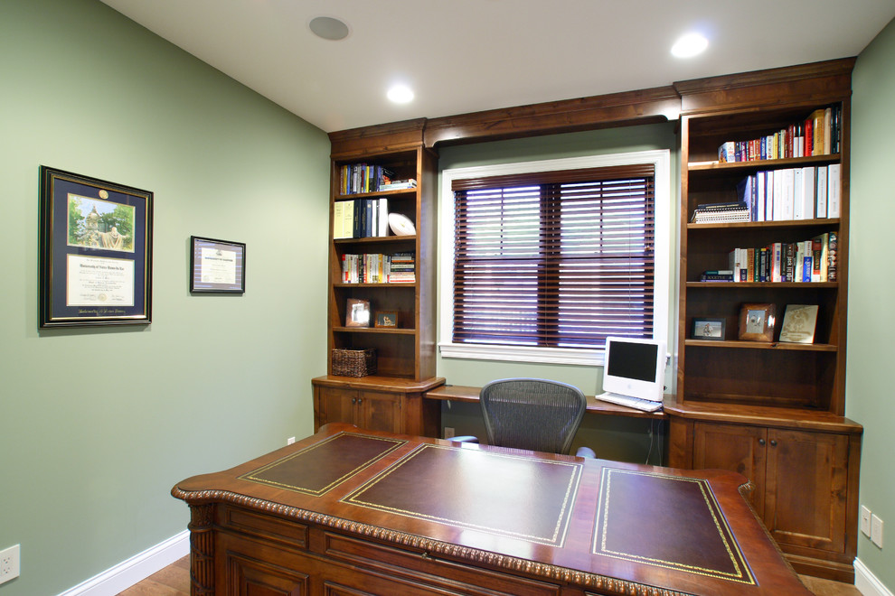 Foto de despacho de estilo americano de tamaño medio con paredes verdes, suelo de madera en tonos medios y escritorio independiente