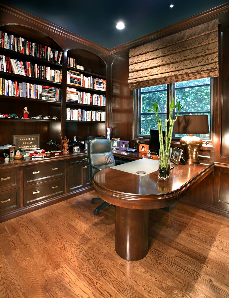 Example of a tuscan built-in desk medium tone wood floor study room design in Los Angeles with brown walls