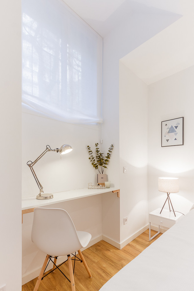 Foto de despacho nórdico pequeño con paredes blancas, suelo de madera en tonos medios y escritorio empotrado