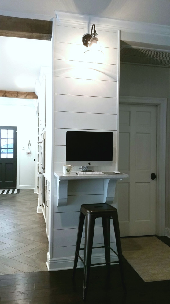 Modelo de despacho campestre pequeño con paredes blancas, suelo de madera oscura y escritorio empotrado