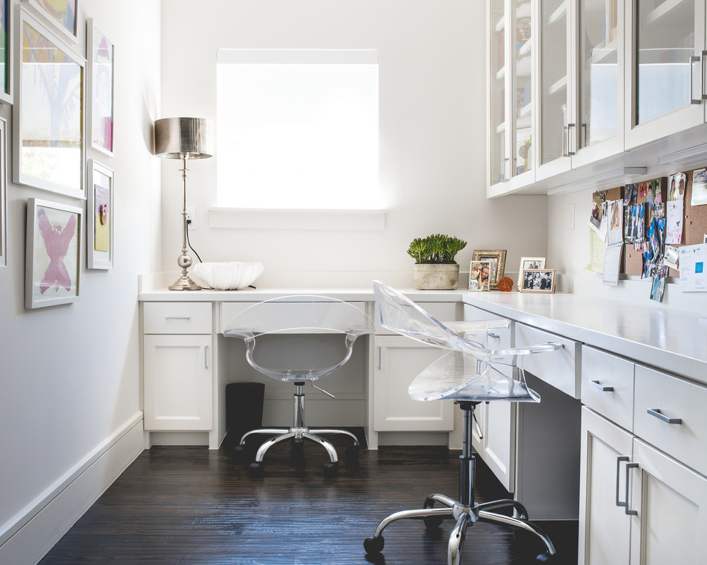 This is an example of a small traditional study in Dallas with white walls, dark hardwood flooring and a built-in desk.