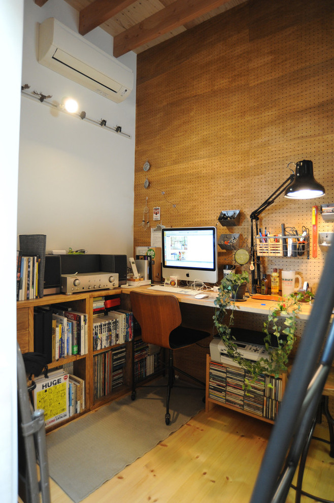 Idéer för att renovera ett litet funkis arbetsrum, med bruna väggar, ljust trägolv och ett inbyggt skrivbord