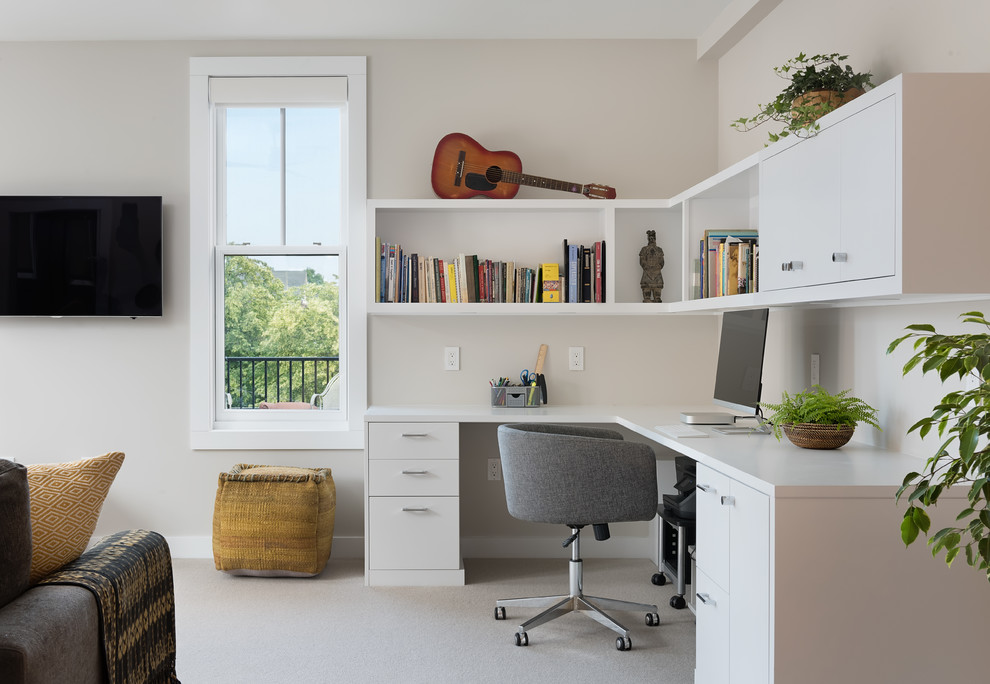 На фото: кабинет среднего размера в современном стиле с ковровым покрытием, встроенным рабочим столом, бежевым полом и бежевыми стенами с