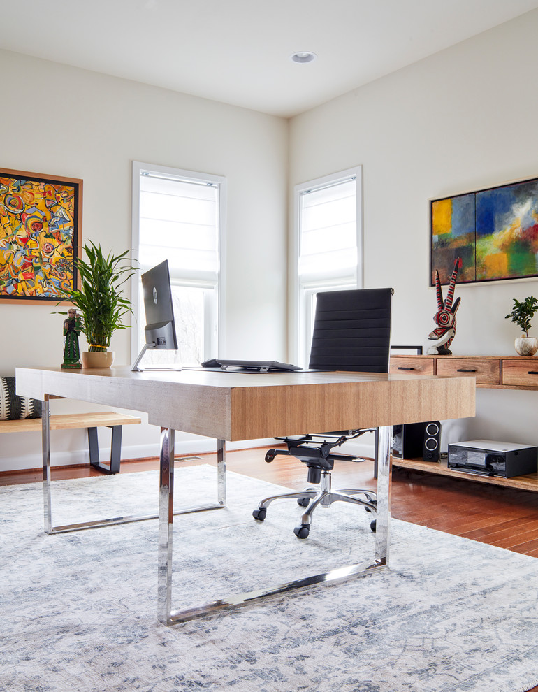 Imagen de despacho moderno de tamaño medio con paredes blancas, suelo de madera en tonos medios, escritorio independiente y suelo marrón