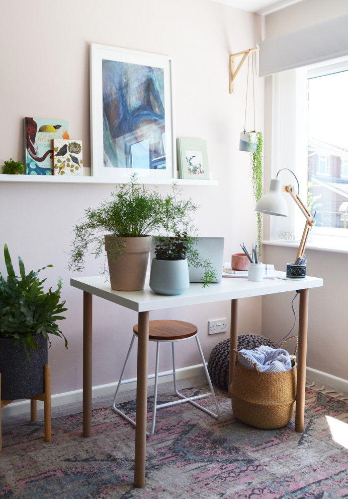 Modelo de despacho contemporáneo pequeño con paredes rosas, moqueta, escritorio independiente y suelo beige