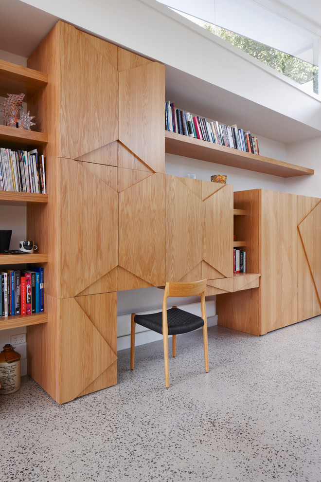 メルボルンにある高級な中くらいなコンテンポラリースタイルのおしゃれなホームオフィス・書斎 (白い壁、コンクリートの床、造り付け机) の写真