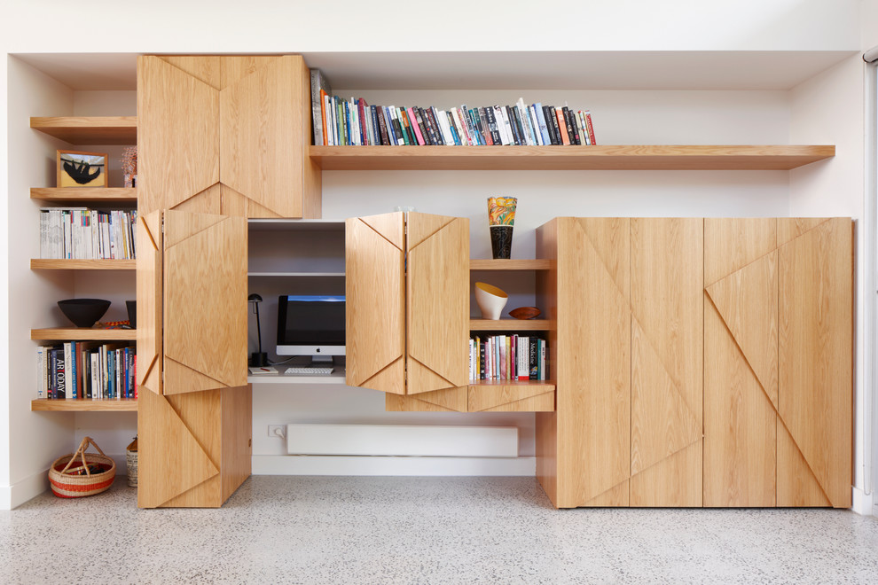 Cette image montre un bureau design de taille moyenne avec un mur blanc, sol en béton ciré et un bureau intégré.