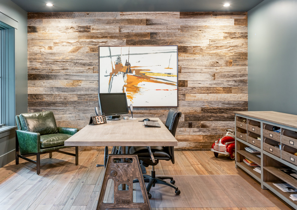 Klassisches Arbeitszimmer ohne Kamin mit Arbeitsplatz, grauer Wandfarbe, braunem Holzboden, freistehendem Schreibtisch, braunem Boden und Holzwänden in Sonstige