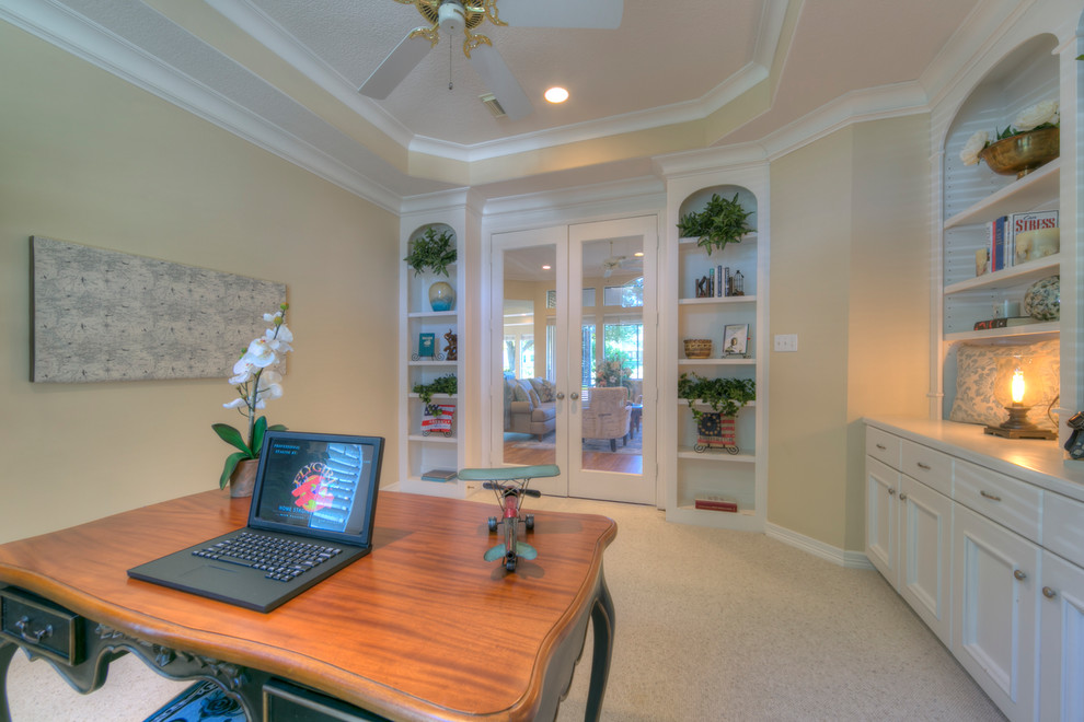 Imagen de despacho clásico de tamaño medio sin chimenea con paredes beige, moqueta, escritorio independiente y suelo beige