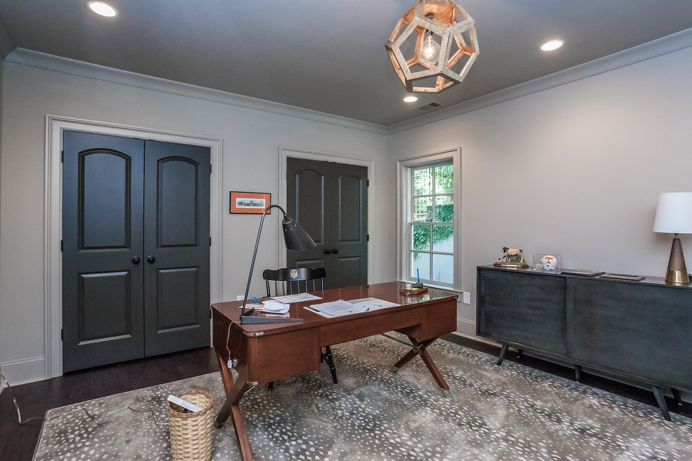Foto de despacho tradicional renovado de tamaño medio con paredes grises, suelo de madera oscura y escritorio independiente