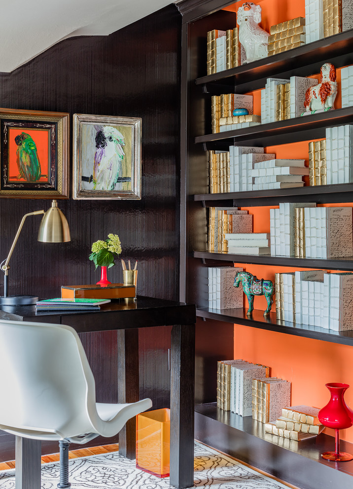 На фото: домашняя библиотека в стиле неоклассика (современная классика) с оранжевыми стенами, паркетным полом среднего тона, отдельно стоящим рабочим столом и коричневым полом с