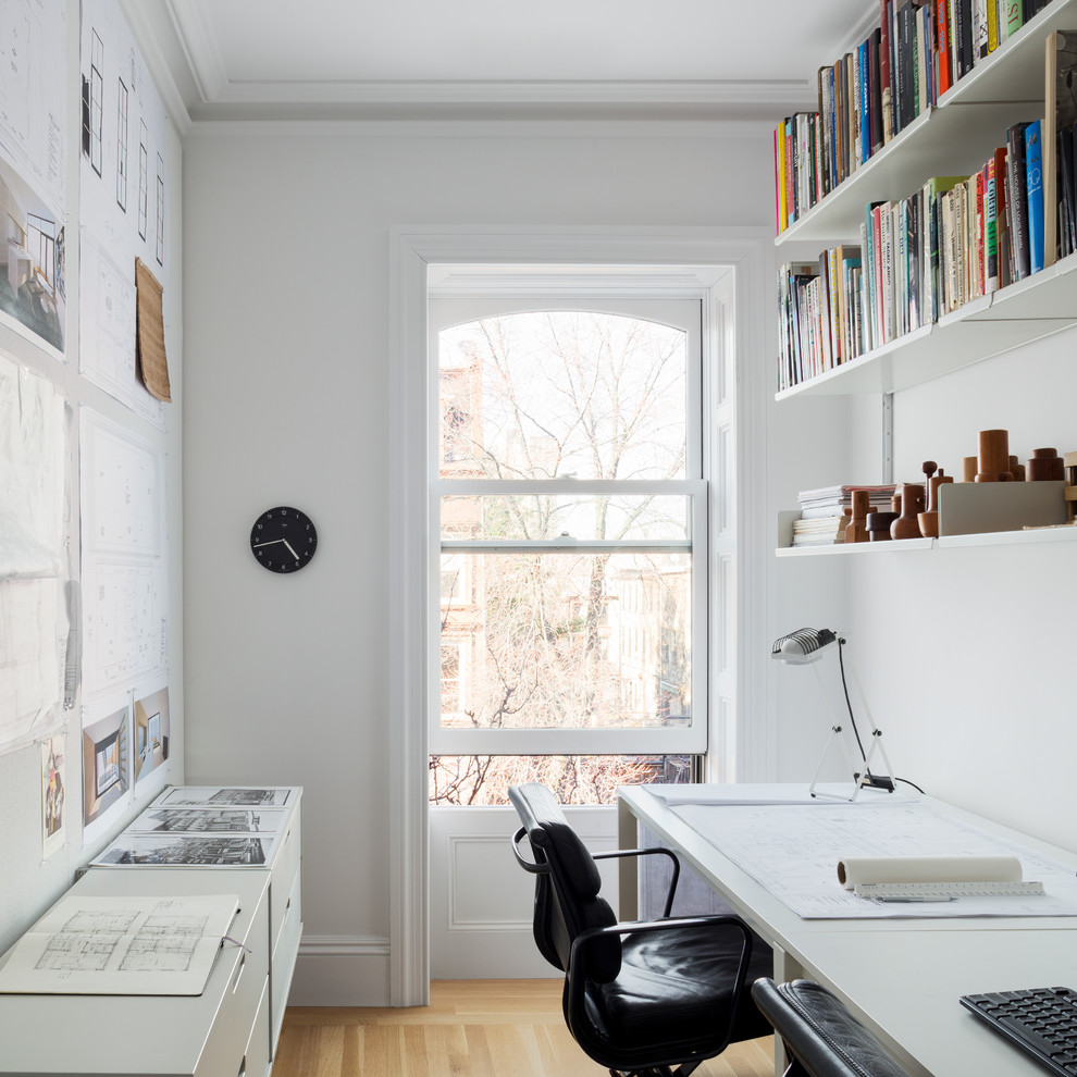 Idéer för ett minimalistiskt arbetsrum, med vita väggar, ett fristående skrivbord och ljust trägolv