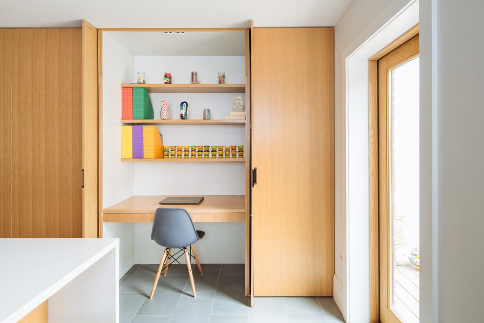 Idee per uno studio minimal con pareti bianche, scrivania incassata e pavimento grigio