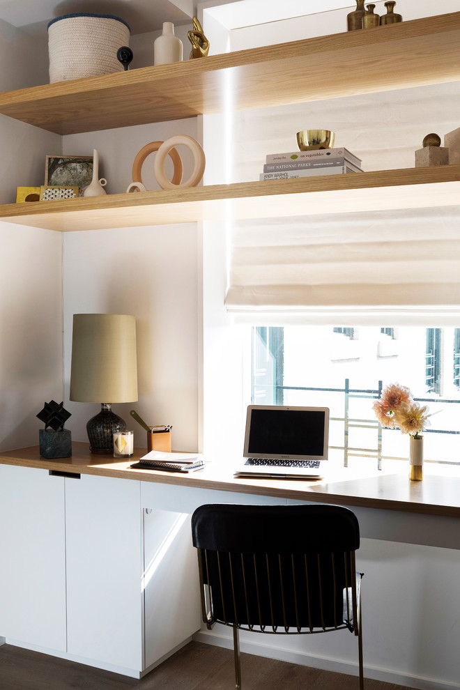 Mittelgroßes Modernes Arbeitszimmer mit grauer Wandfarbe, braunem Holzboden und Einbau-Schreibtisch in New York
