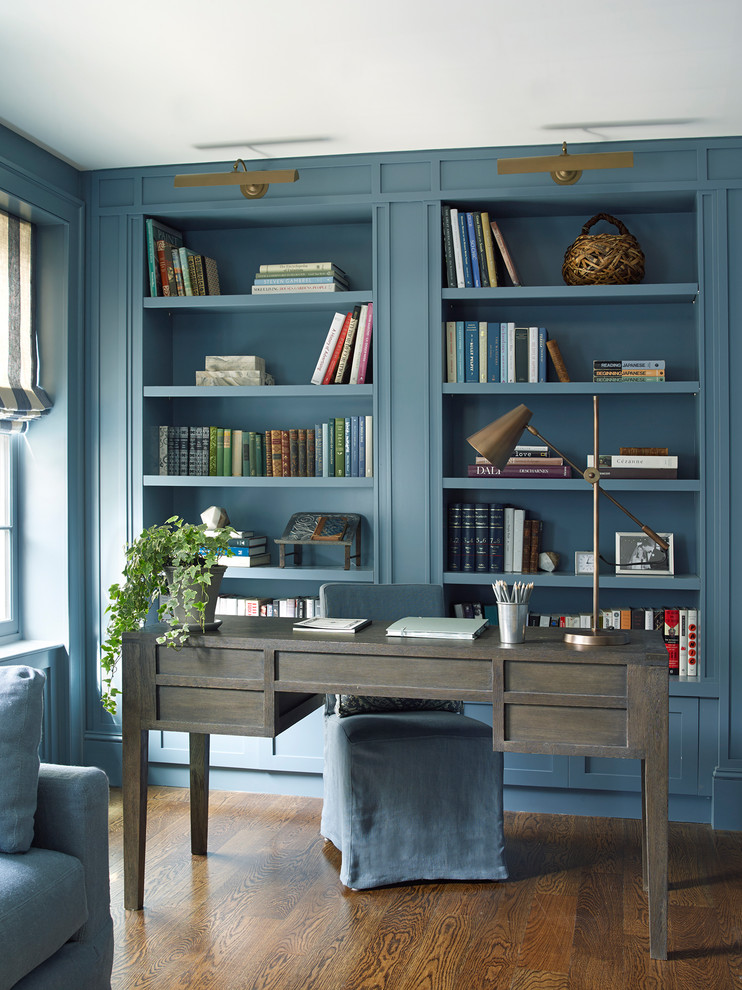 Foto di uno studio tradizionale di medie dimensioni con libreria, pareti blu, parquet scuro, scrivania autoportante e pavimento marrone